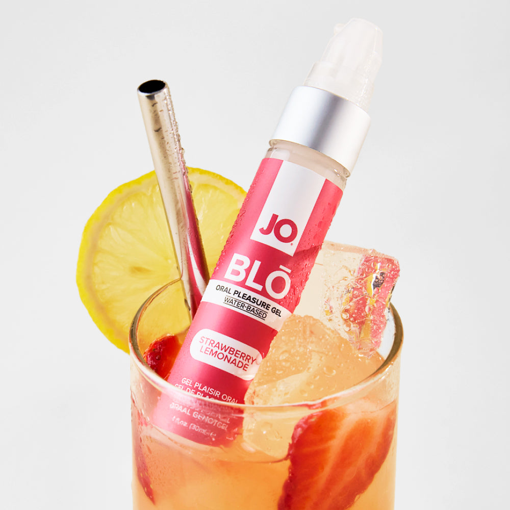 BLO Strawberry Lemonade bottle propped in a glass of iced pink lemonade with a metal straw