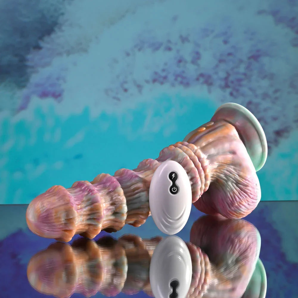 Evolved Fantasy dildo in multicolour lying on its side, suction base to the right, remote behind