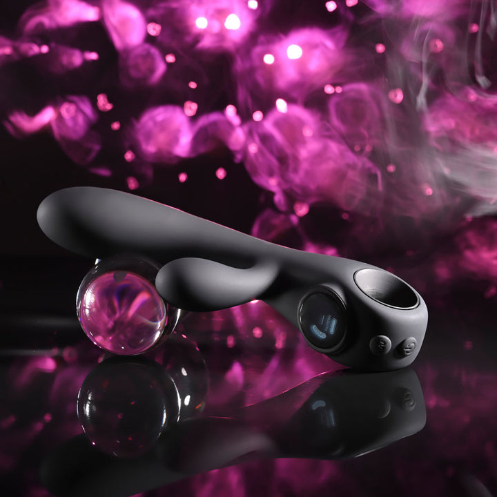 Evolved Black Magic in Black tilted on a reflective surface beside a glass sphere