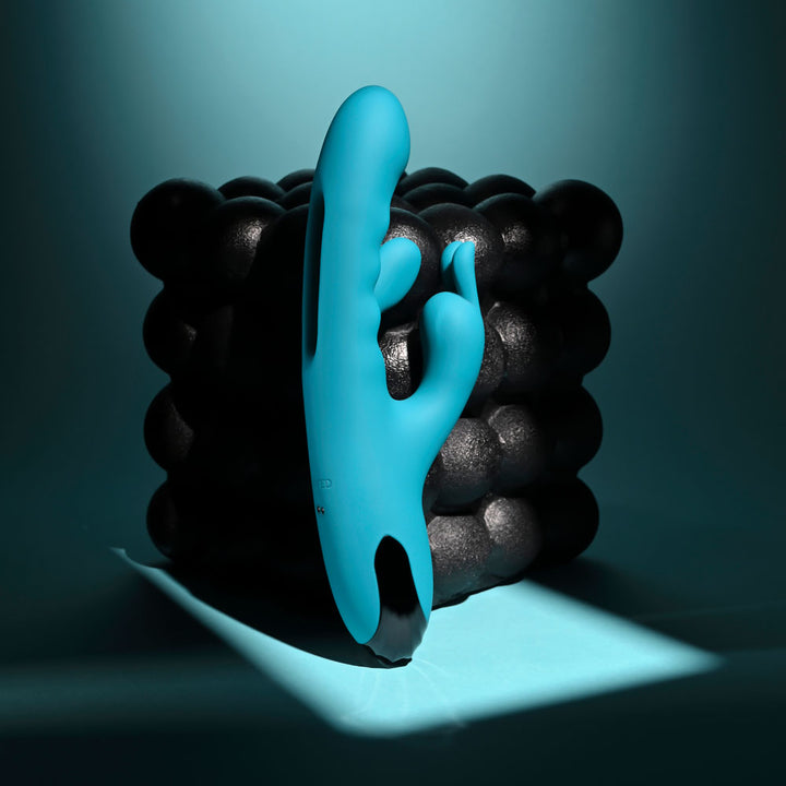 Evolved Bunny Tapper in Teal standing upright against a wall of glossy black spheres