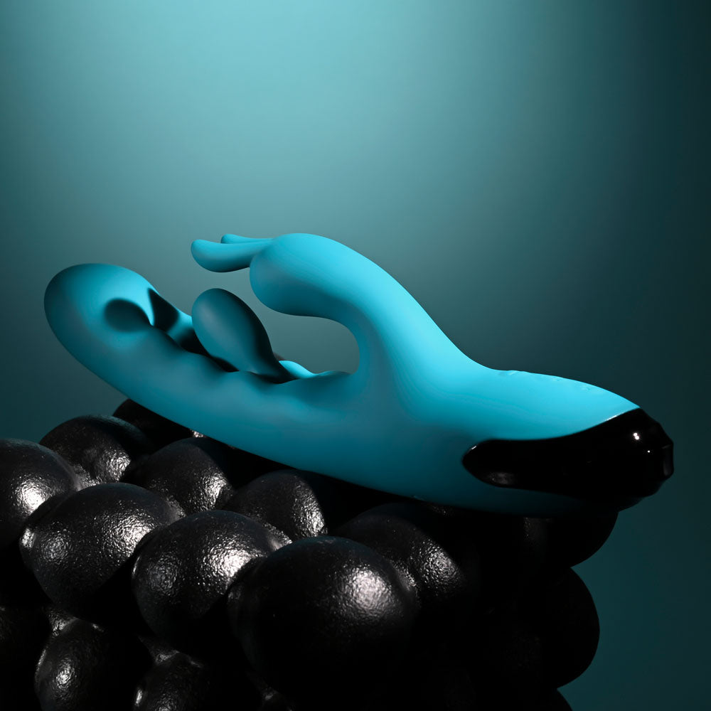 Evolved Bunny Tapper in Teal laid across black spheres, ears pointing left