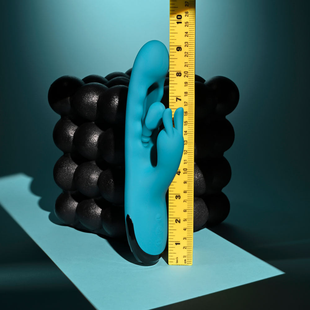 Evolved Bunny Tapper in Teal beside an upright tape measure, reading about 9 inches