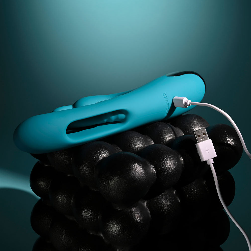Evolved Bunny Tapper in Teal lying flat with its white USB charging cable attached