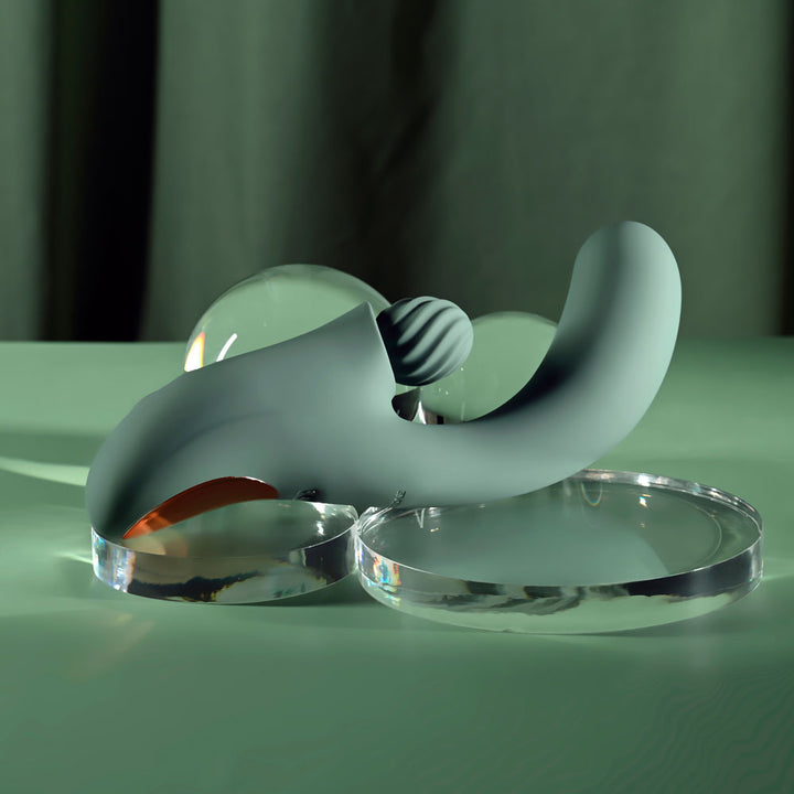 Evolved Spiral Charm in sage green lying flat, rose gold handle panel to the left