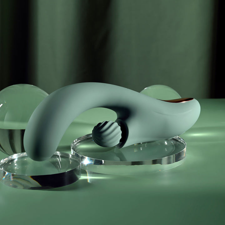 Evolved Spiral Charm in sage green lying flat with the spiral clitoral ball facing the camera