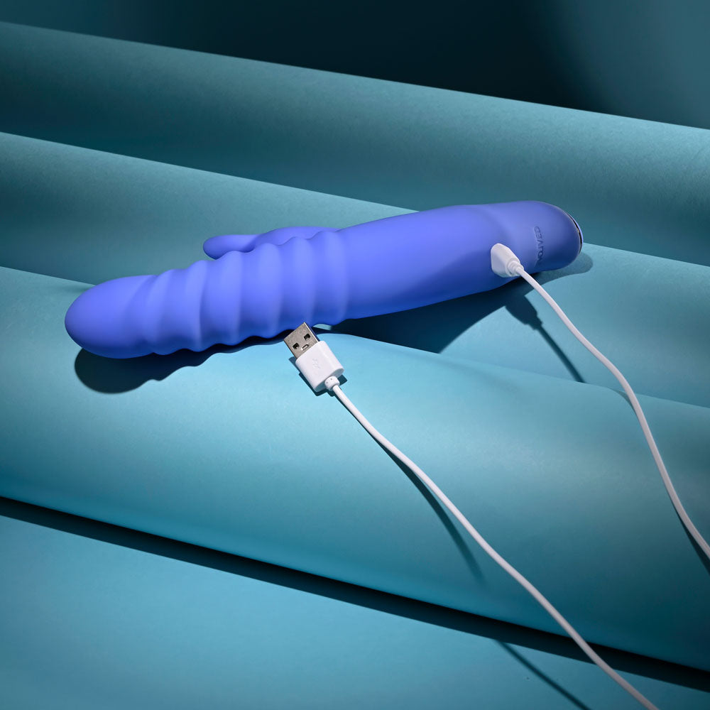 Evolved Knock Knock in blue-violet lying flat with its white USB charging cable attached
