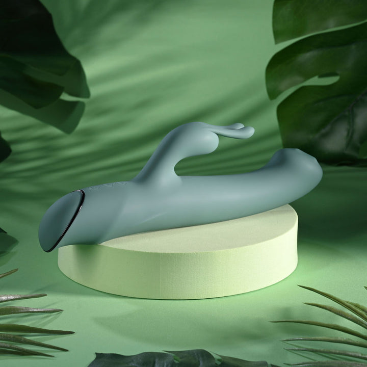 Evolved Satin Swirl in sage green on a podium, turned to show the dark cap on the handle