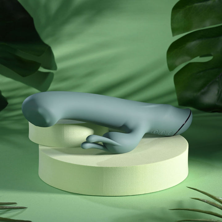 Evolved Satin Swirl in sage green angled across the podium, ears pointing down to the left