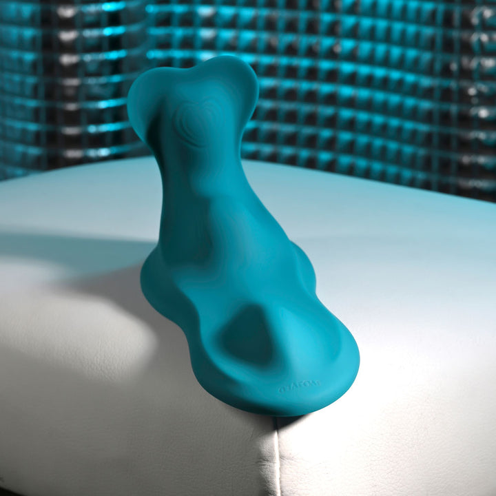 Evolved Bump & Grind in Teal resting on a white cushion, head towards the camera