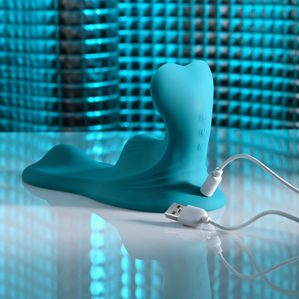 Evolved Bump & Grind in Teal with its white USB charging cable plugged into the base