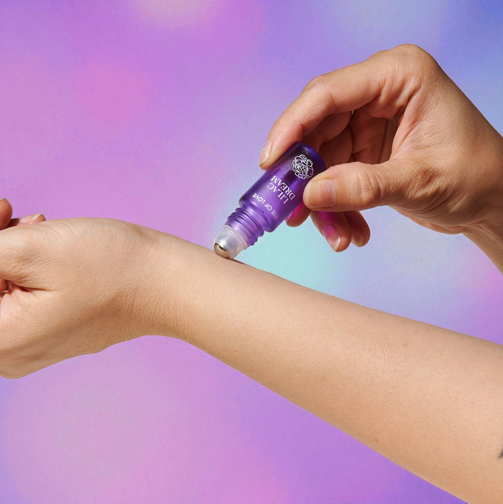 Purple Lilac Dream roll-on being applied to a wrist against a lilac background