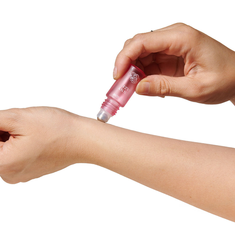 Close-up of the Sunny Daze roll-on ball being rolled onto a wrist, white background