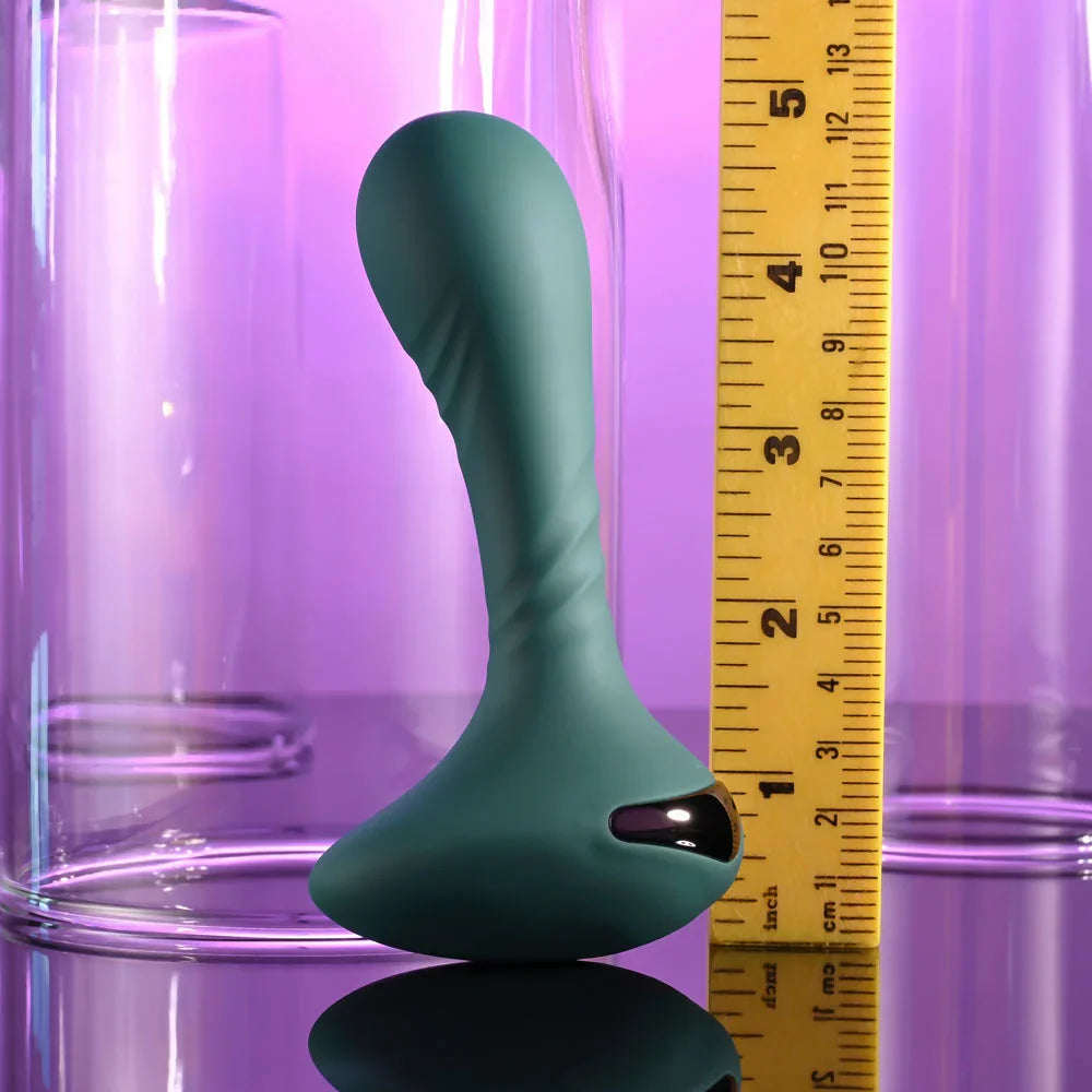 Gender X Goes Anywhere vibrator in Green upright beside a tape measure, about 12 cm