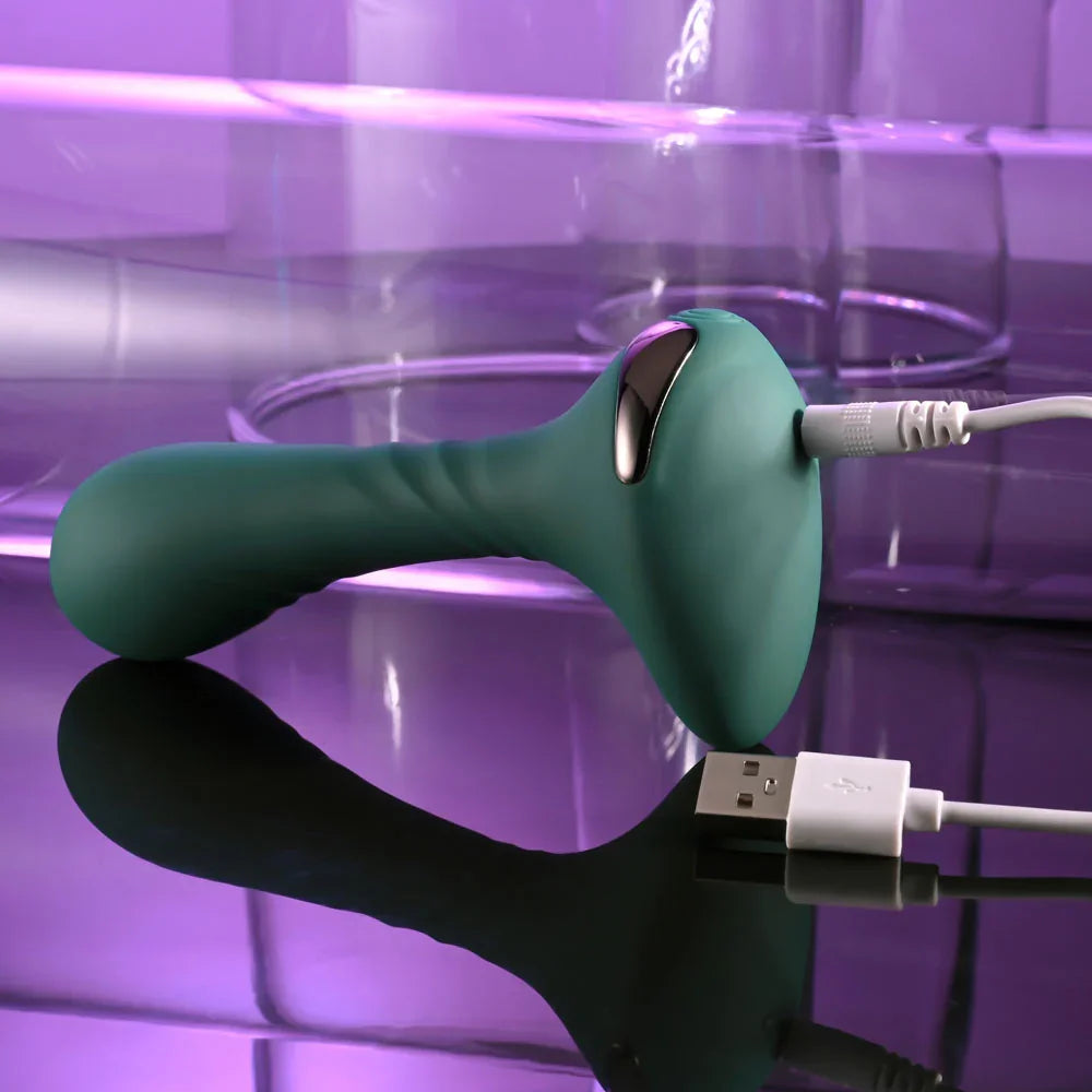 Gender X Goes Anywhere vibrator in Green with its magnetic USB charging cable attached