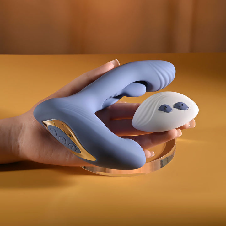 Gender X Flapjack in Blue held in a hand alongside its oval remote