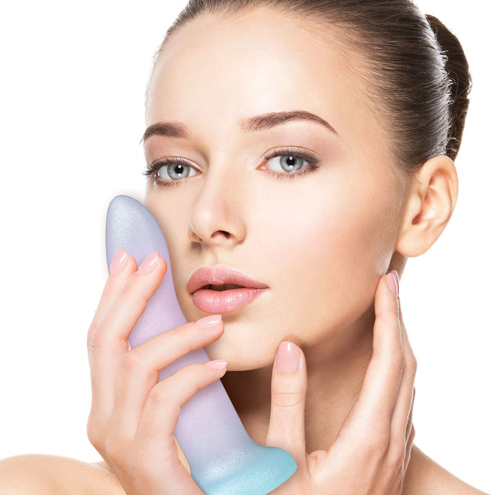 Model holding the lilac and aqua Mixers Blueberry Crush dildo against her cheek