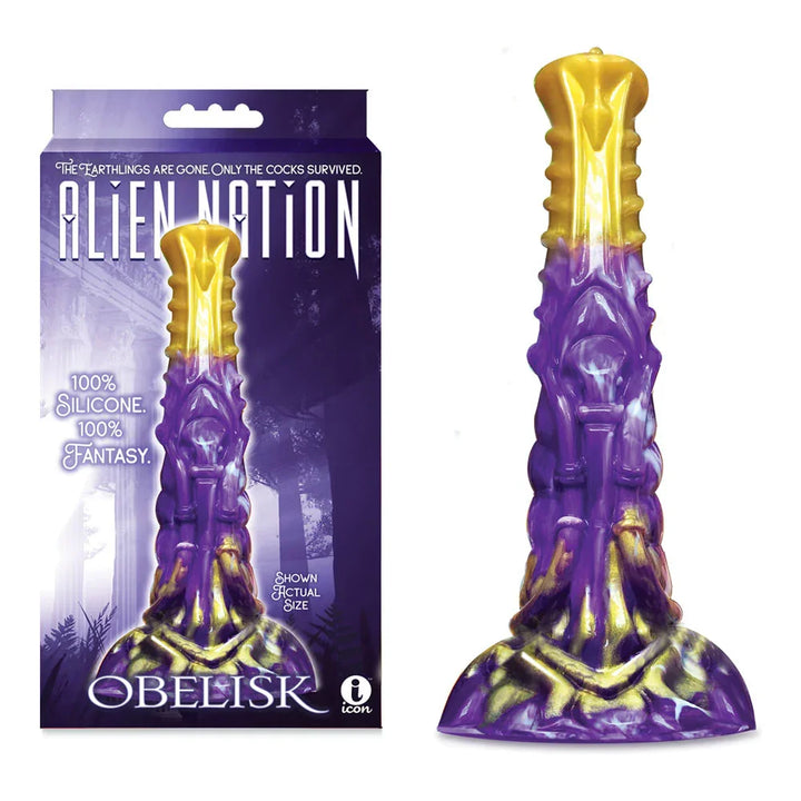 Alien Nation Obelisk fantasy dong in Purple with a gold tip, beside its retail box