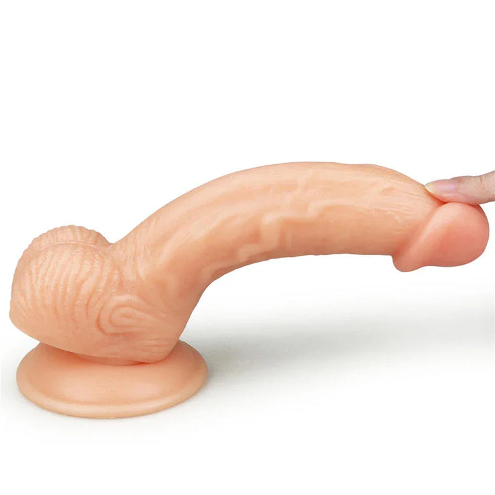 Ultra Soft Dude 8 inch dong bent over by a fingertip on its suction base