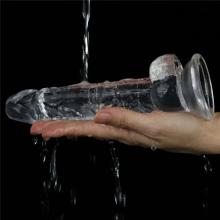 Flawless Clear dildo rinsed under running water over a hand, showing it is fully waterproof