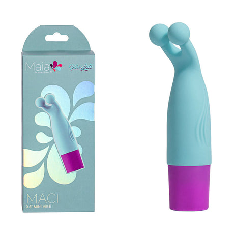 A turquoise mini vibrator with a dual ball design and purple base, shown with its packaging labeled Maia MACI - Light Blue 8.9 cm USB Rechargeable Bullet. Made from body-safe silicone, it has magnetic charging. The display features a light blue background with floral patterns.