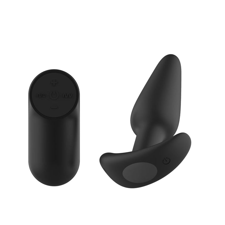 Passion Play Vibrating Butt Plug in Black tilted, showing the button recess in the base