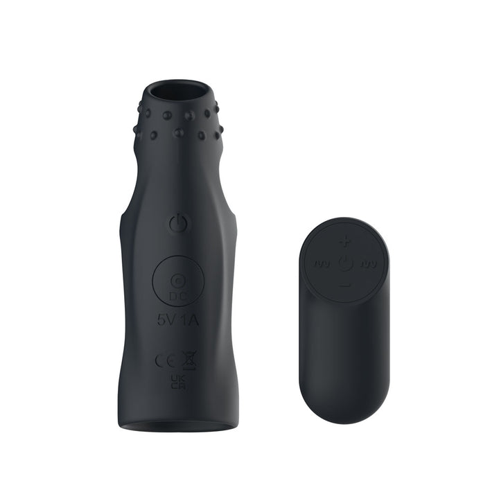 Passion Play Cockring Sleeve in Black seen end on, nubbed collar uppermost, remote at right