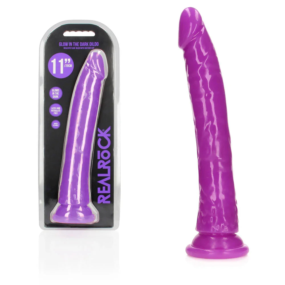 REALROCK 28 cm Glow in the Dark Slim Dildo in Purple, blister pack beside the neon purple dildo