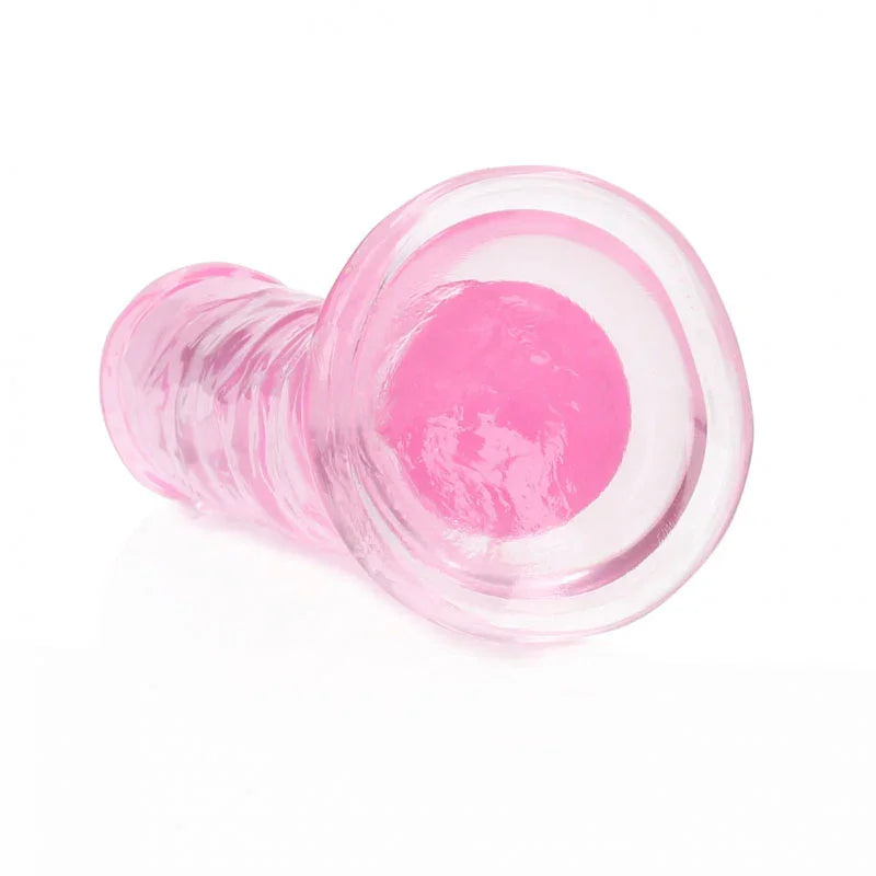REALROCK 15.5 cm Straight Dildo in Pink, lying down with the suction base facing the camera