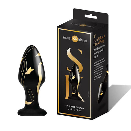 A black and gold handblown glass plug with gold swirls is shown beside its Secret Kisses box, which emphasizes its beginner-friendly shape, a 4-inch hypoallergenic design, and includes the product image.