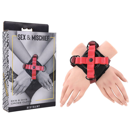 The S&M Exs & Ohs Cross Cuffs - Red/Black Restraints are displayed beside mannequin hands. The box shows a similar image, with Sex & Mischief at the top, Restraint at the bottom, and the product name on the side.