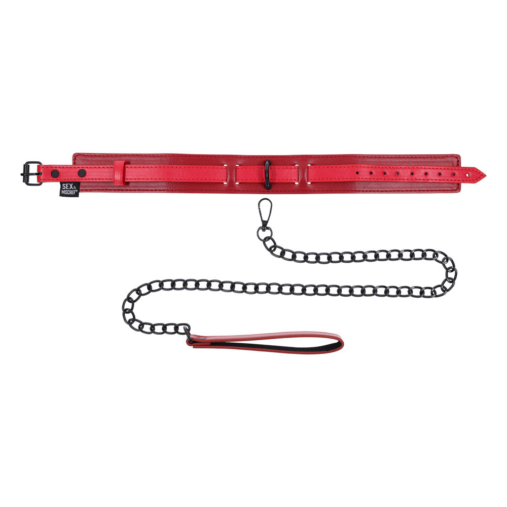 The S&M Exs & Ohs Collar and Leash, a red faux leather collar with a black buckle and sizing holes, is paired with a matte black chain leash featuring a matching red looped handle. A tag reads SEX & MISCHIEF, and the leash connects to the collar with a clasp against a white background.