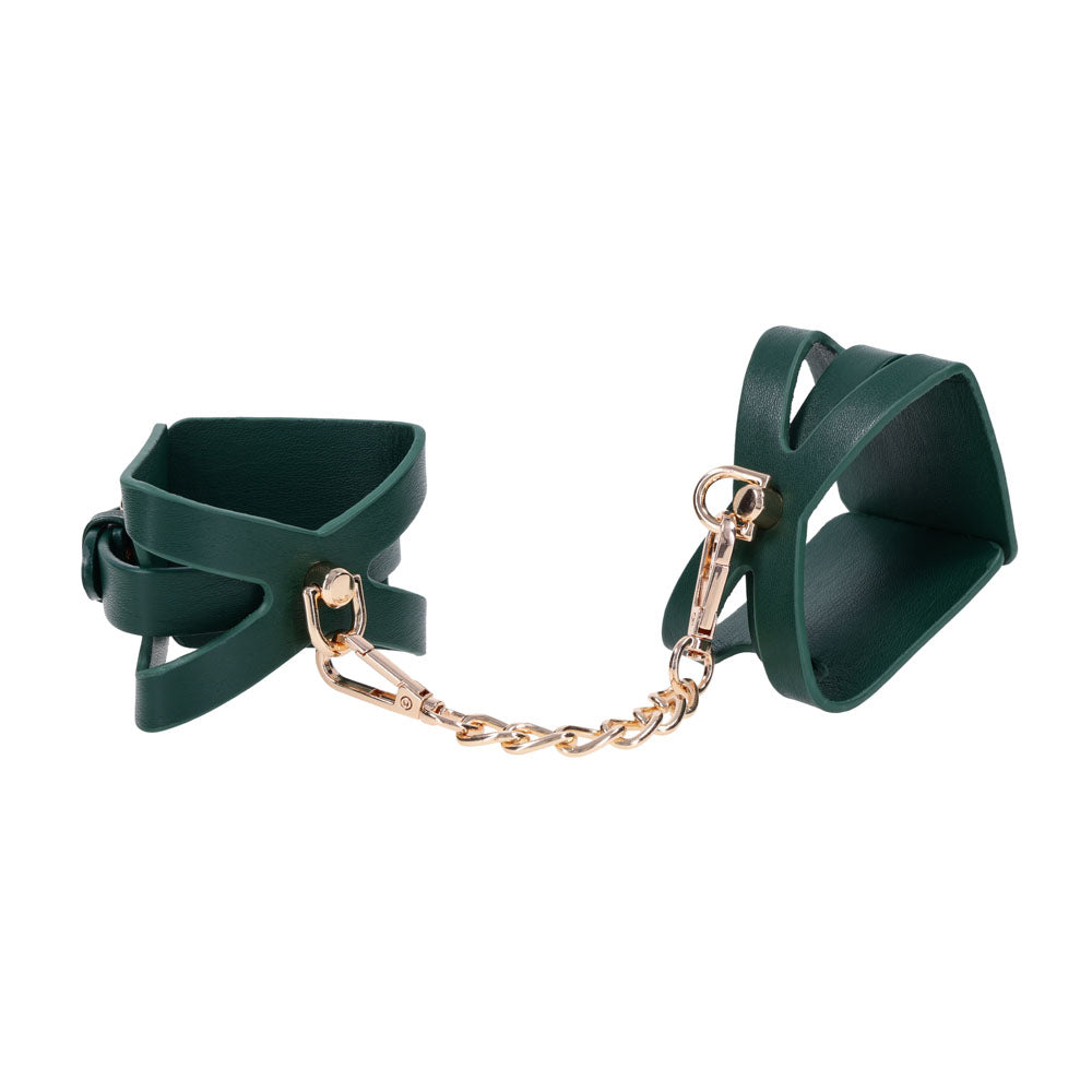 Indica cutout cuffs angled apart on white with the gold chain drawn taut between them