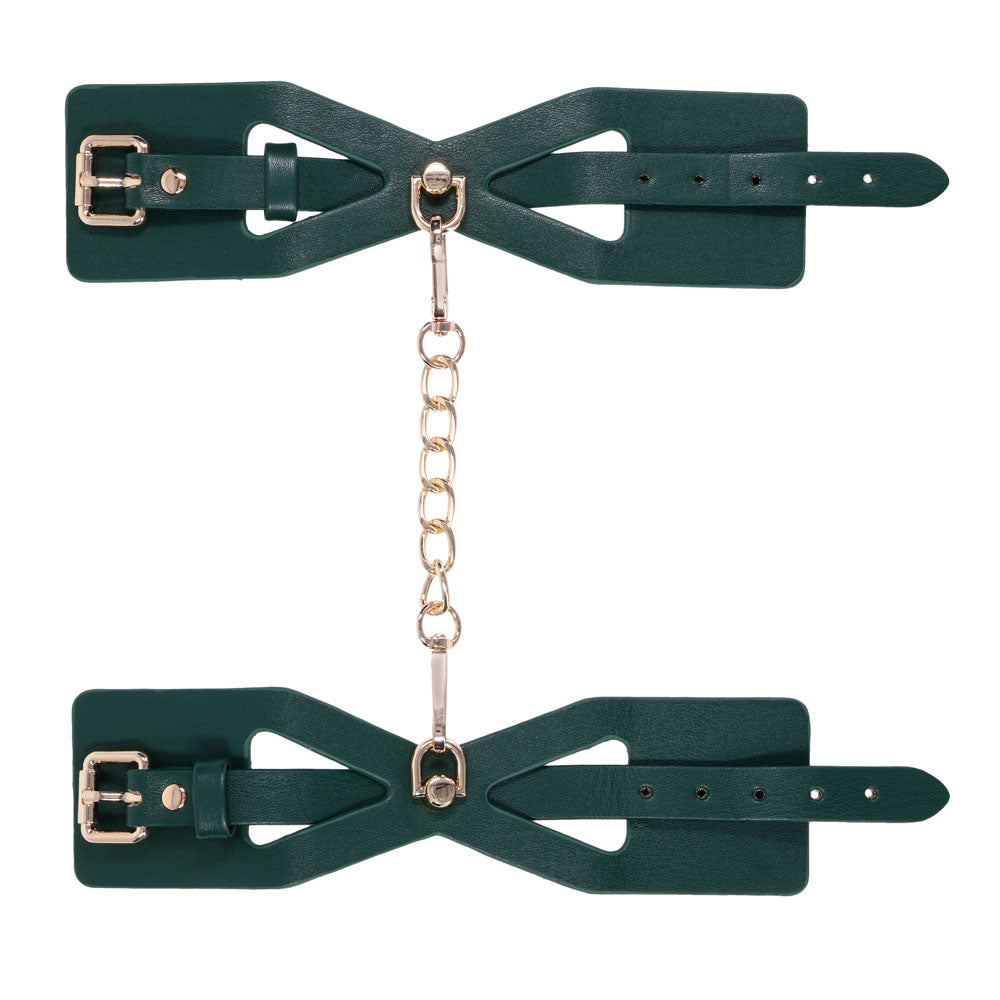 Both Indica cuffs laid flat with the gold chain running vertically between them