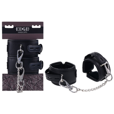The EDGE Handcuffs - Black Restraints feature metal buckles and a chain for secure restraint, with adjustable buckle closures. Displayed both in and out of their packaging, the box showcases EDGE and HANDCUFFS with a geometric pattern.