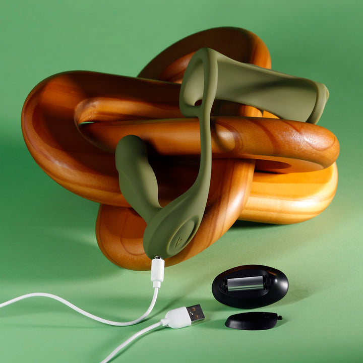 Prostate Power Pack with its USB charging cable and remote on a green backdrop