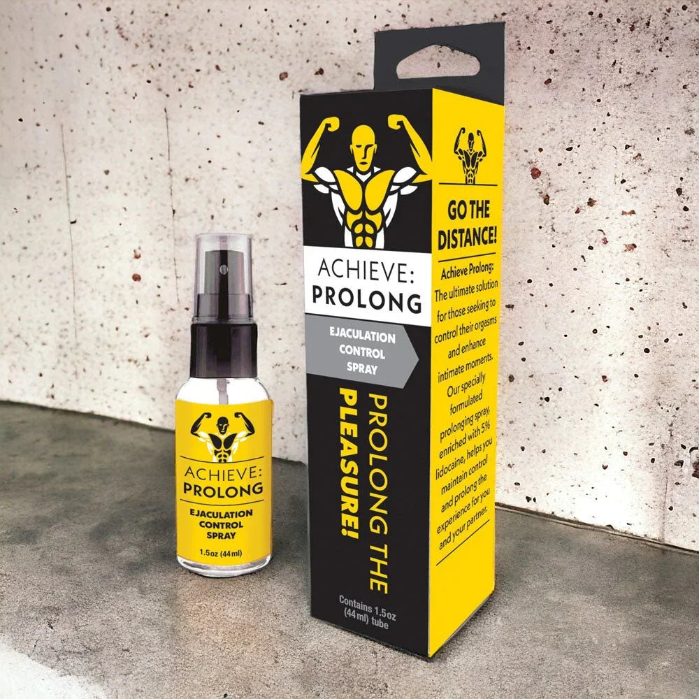Achieve Prolong spray and carton staged against a pale concrete wall