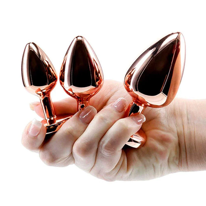 Rose Gold Heart Gem set, all three plugs held between fingers for scale