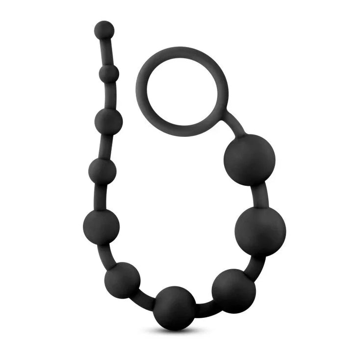 Black silicone anal beads curled into a loop, pull ring at the top