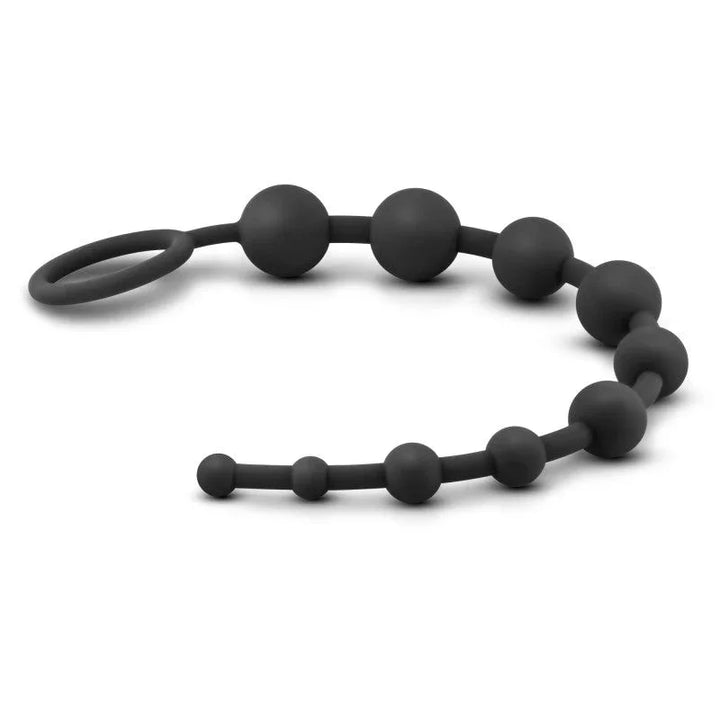 Black anal beads laid out in a flat wave, showing all ten graduated beads