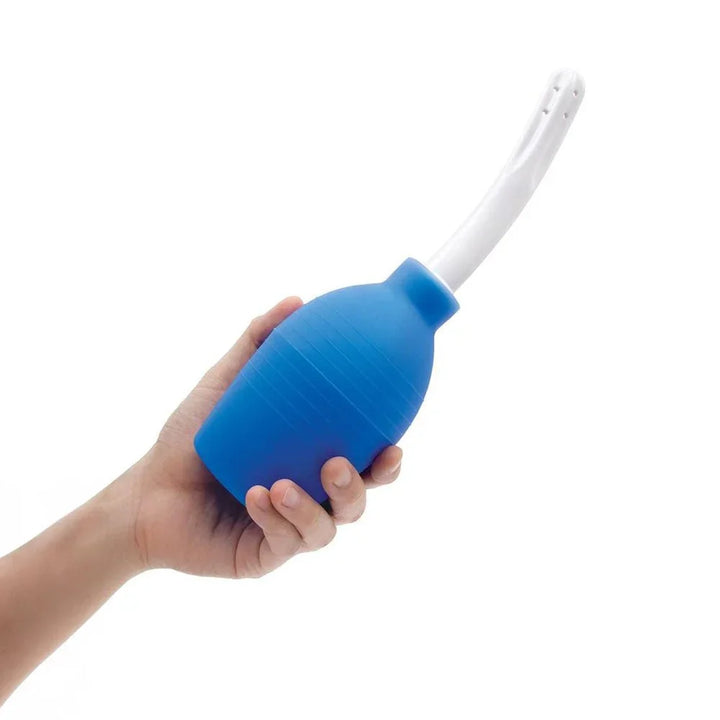 A hand squeezing the blue AquaClean Medical Grade bulb, white nozzle angled upward