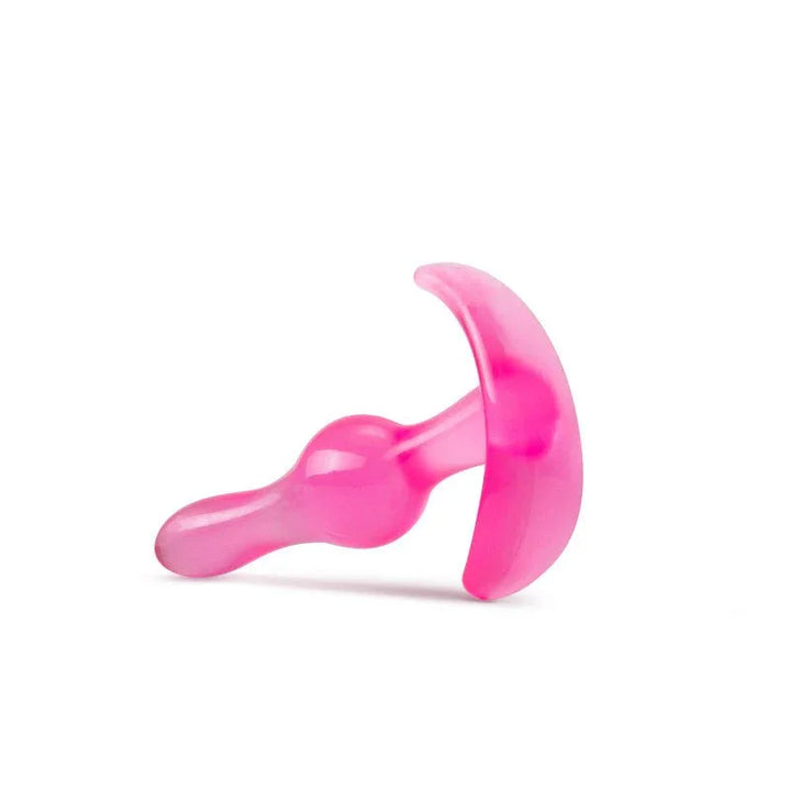 Pink curvy anal plug lying down, curved base turned toward the camera
