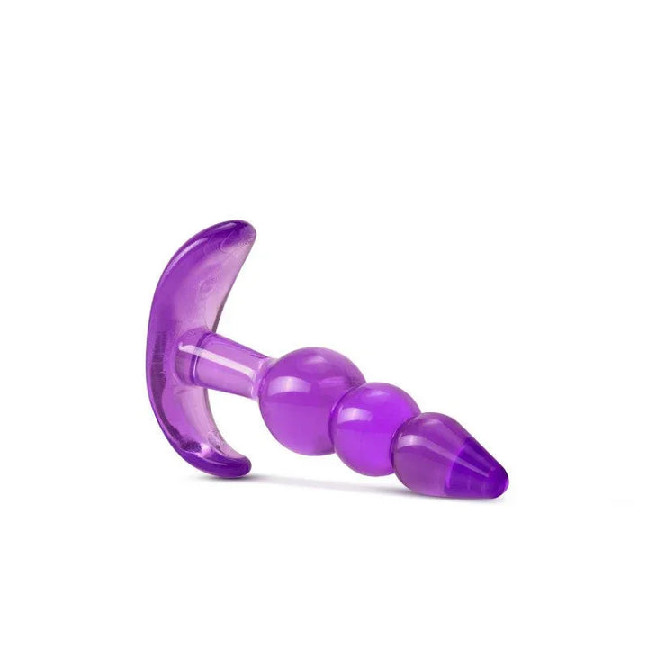 Purple triple bead plug lying on its side, beads tapering to the right
