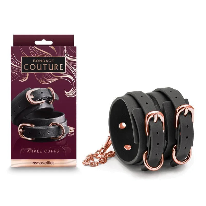 Bondage Couture ankle cuffs in Black with rose gold buckles and chain, beside the burgundy box