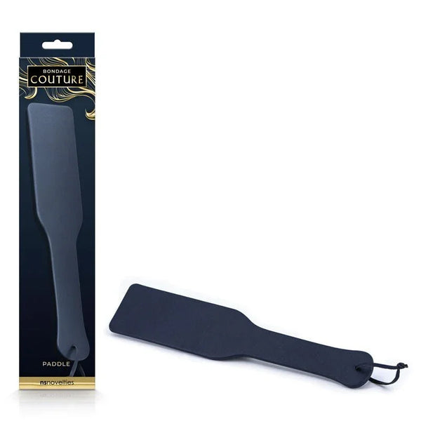 Bondage Couture paddle in Blue, navy paddle with wrist loop beside its dark retail box
