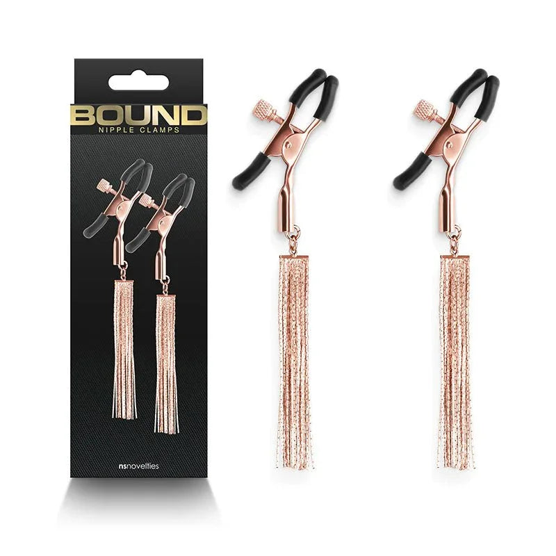 Bound nipple clamps in Rose Gold with chain tassels, pair beside the black Bound box