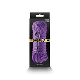 The image displays a black and gray box with gold text BOUND, containing 7.6m of non-chafing purple rope made from durable polyester fiber. The coil is branded as nsnovelties.