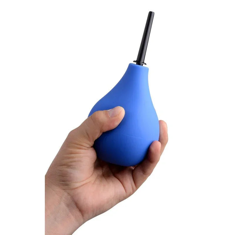 A hand squeezing the blue anal douche bulb, showing its size in the palm