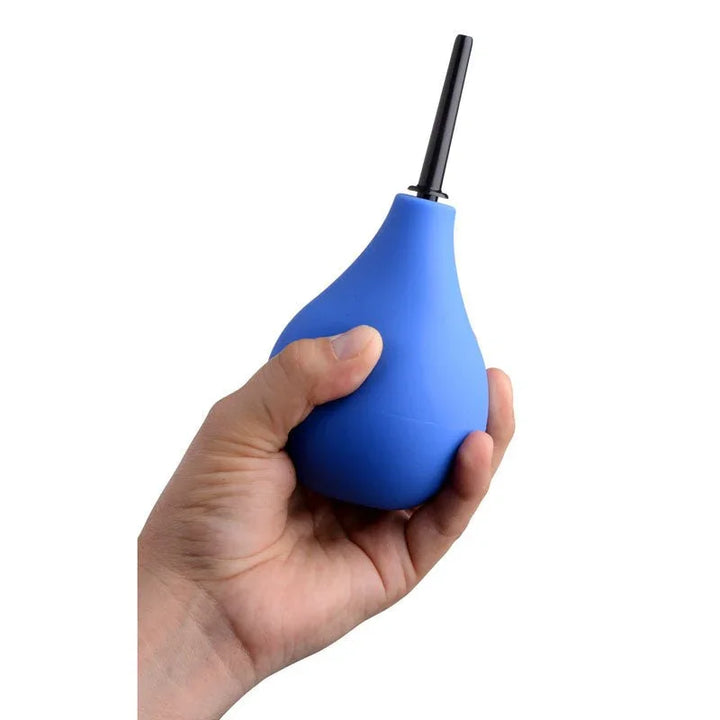 A hand squeezing the blue anal douche bulb, showing its size in the palm