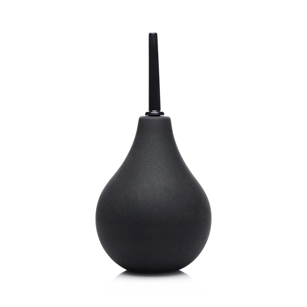 Black silicone enema bulb standing upright on white with the thin nozzle fitted