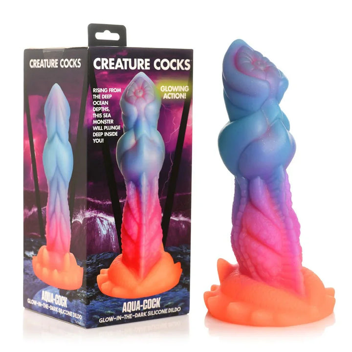 Creature Cocks Aqua-Cock glow-in-the-dark dildo beside its retail box shown front and back